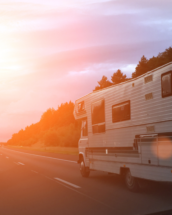 Motorhome driving on road in sunset