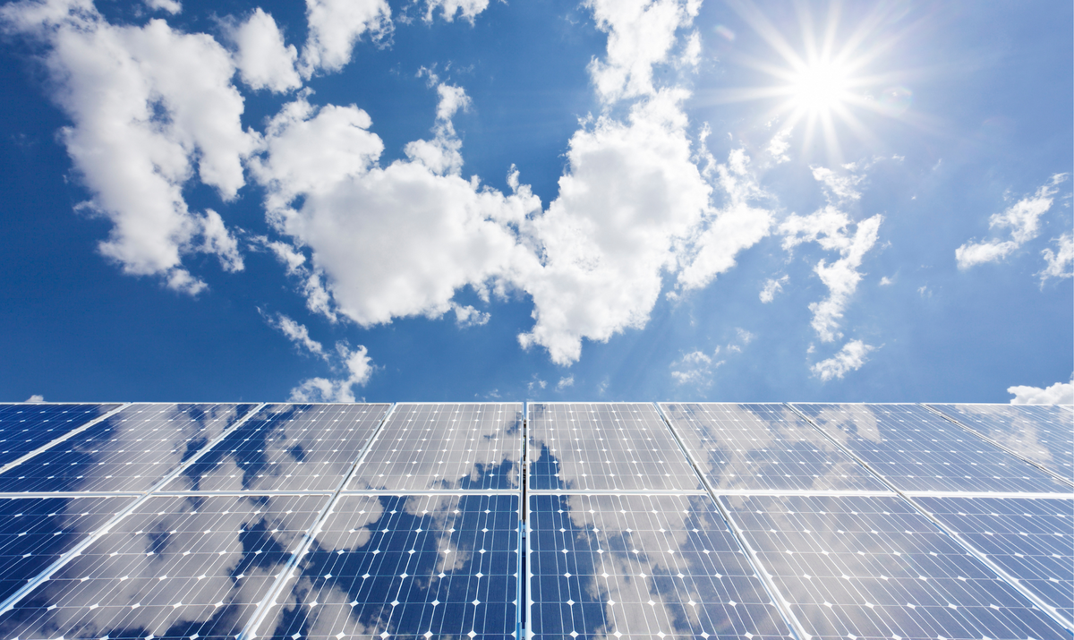 Solar panel array with sky and clouds above